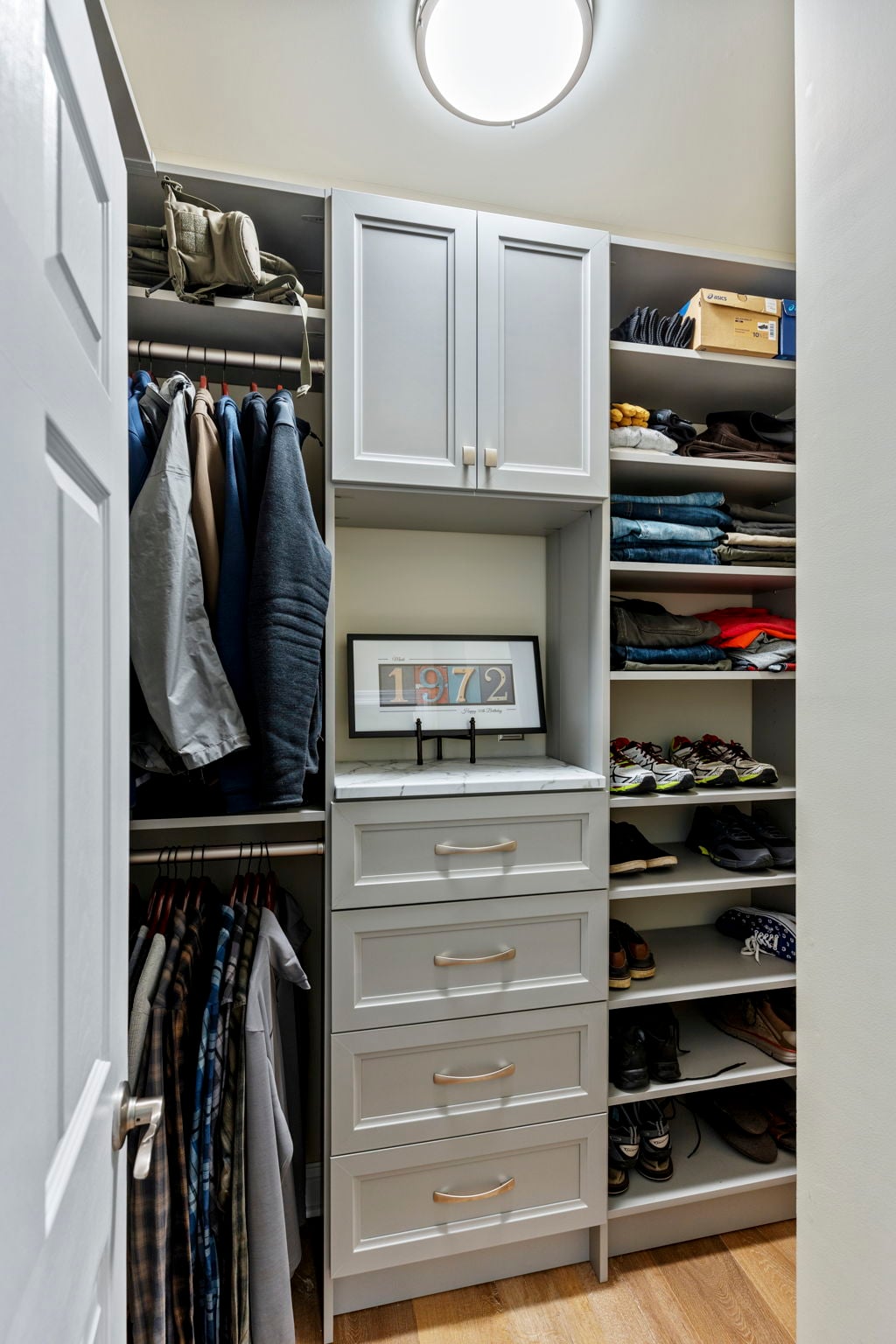 Beautiful organized closet with drawers, counter, hang, shoe shelves