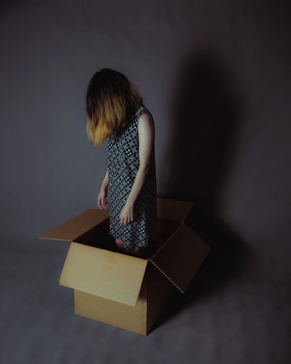 girl in box, tired from decluttering and decision fatigue